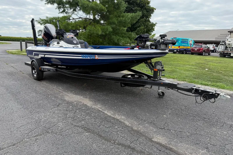 Slide: The Image of 2018 SKEER ZX190 boat on trailer, parked outdoors near trees and vehicles. - 1
