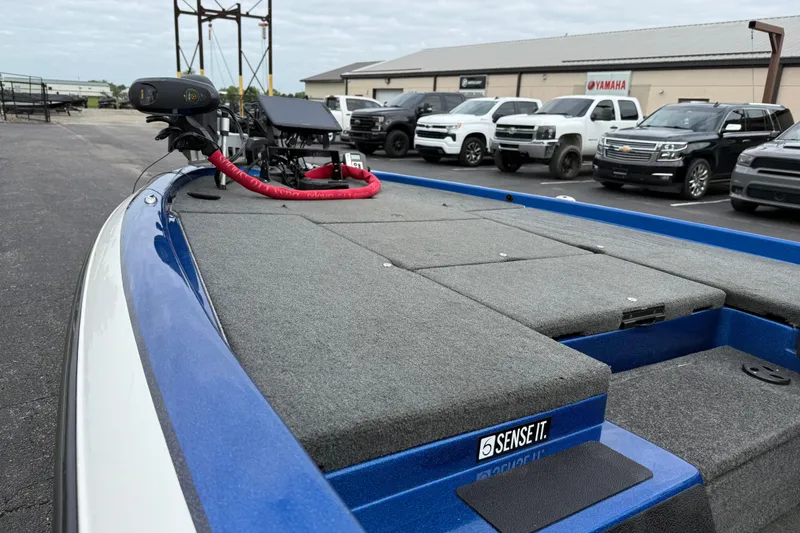 Slide: The Image of 2018 SKEER ZX190 boat with gray deck, parked near trucks and a Yamaha sign. - 14