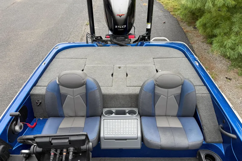 Slide: The Image of 2018 SKEER ZX190 boat interior with dual seats and motor, parked on pavement. - 21