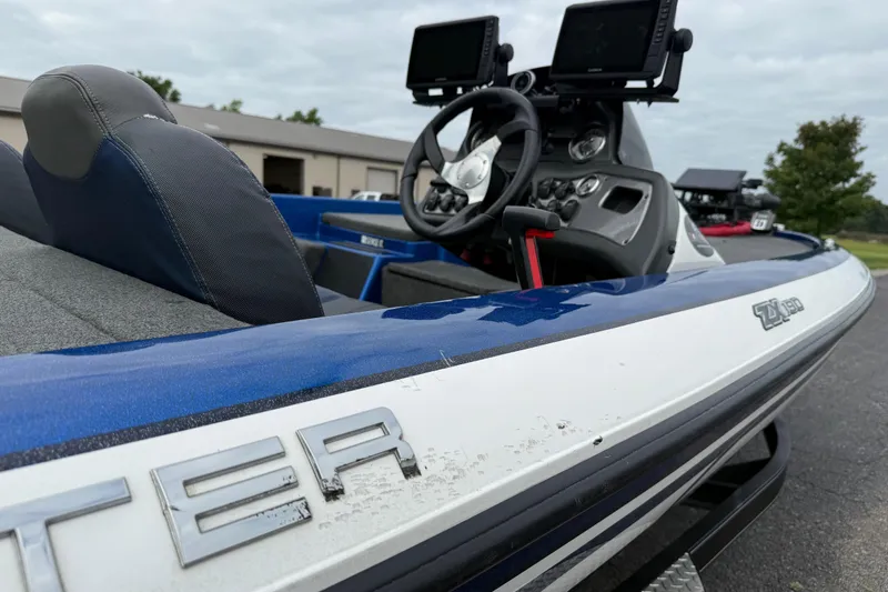 Slide: The Image of 2018 SKEER ZX190 boat with dual monitors and steering wheel, parked outdoors. - 6