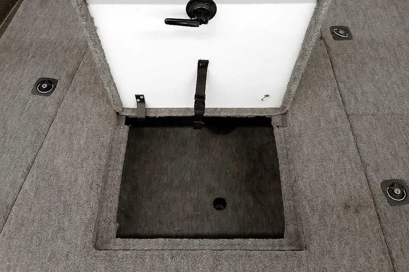Slide: The Image of 1996 Ranger 487VS boat storage compartment with gray carpeted interior and latch. - 16