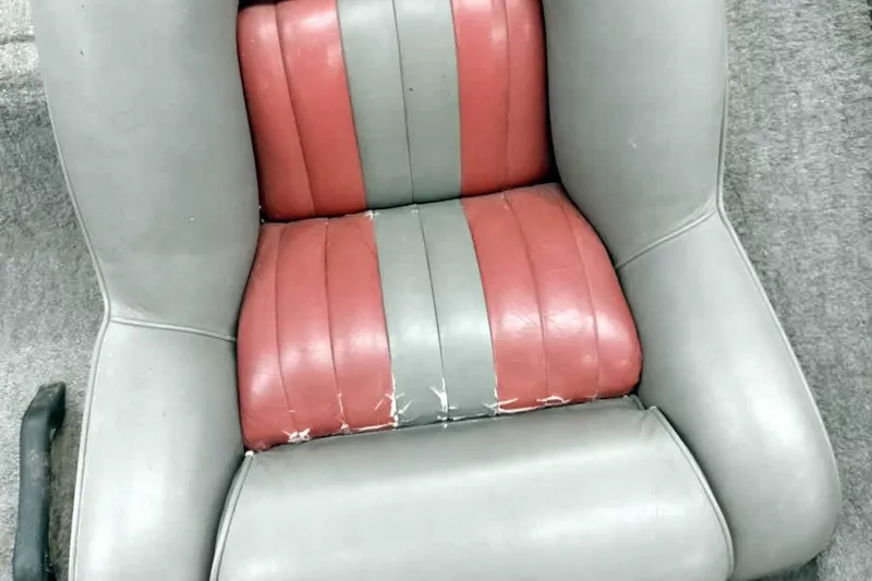 Slide: The Image of Worn seat of a 1996 Ranger 487VS boat, featuring red and gray upholstery. - 25