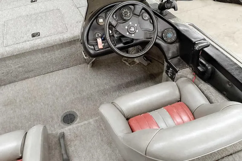 Slide: The Image of 1996 Ranger 487VS boat interior with steering wheel and gray-red seating. - 29