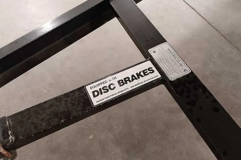 Slide: The Image of 1996 Ranger 487VS trailer frame with disc brakes label, black metal structure. - 7