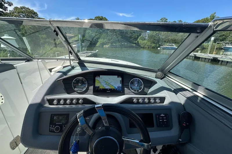 Slide: The Image of 2016 Cobalt R5 boat dashboard with navigation screen and steering wheel on a sunny day. - 11