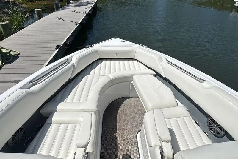Slide: The Image of 2016 Cobalt R5 boat with white seating, docked by a calm waterway. - 16