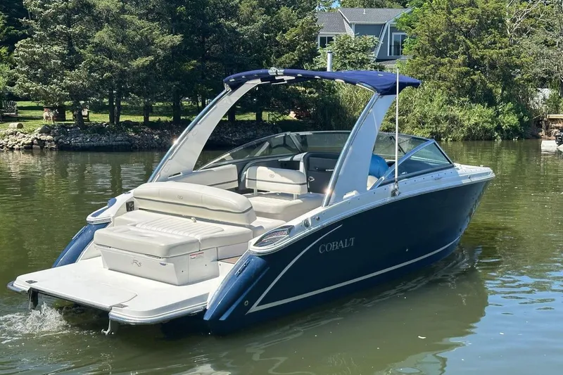 Slide: The Image of 2016 Cobalt R5 boat on a serene lake with lush greenery. - 3
