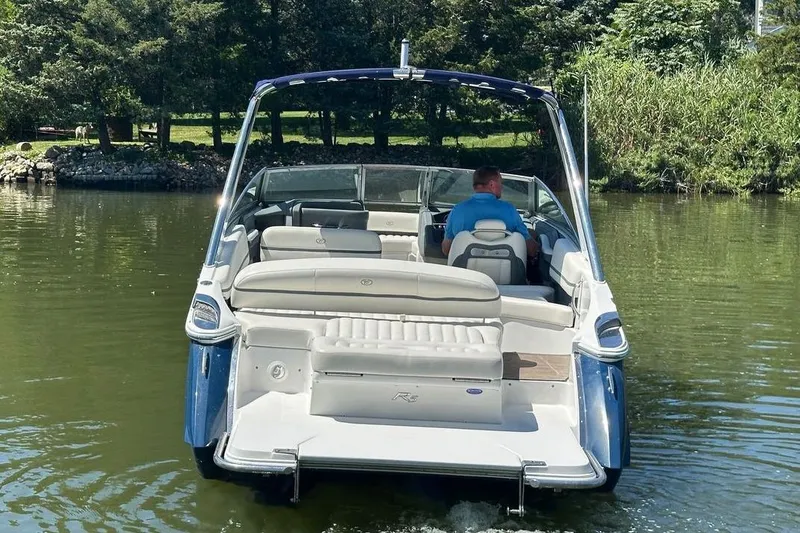Slide: The Image of 2016 Cobalt R5 boat cruising on a calm lake with lush greenery. - 4