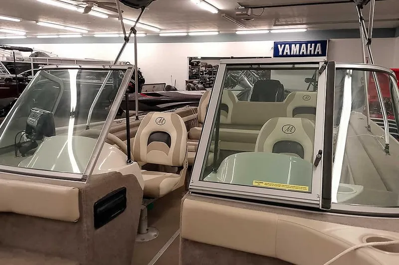 Slide: The Image of 2005 Monark King 185 boat interior with beige seating in showroom. - 12