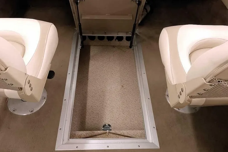 Slide: The Image of Interior of a 2005 Monark King 185 boat with beige seating and carpeted flooring. - 28