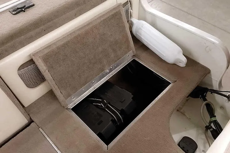 Slide: The Image of Open storage compartment in a 2005 Monark King 185 boat with visible battery. - 36