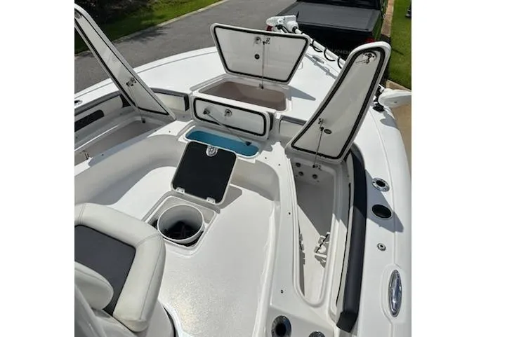 Slide: The Image of 2024 Tidewater 2300 Carolina Bay boat with open storage compartments and seating area. - 12