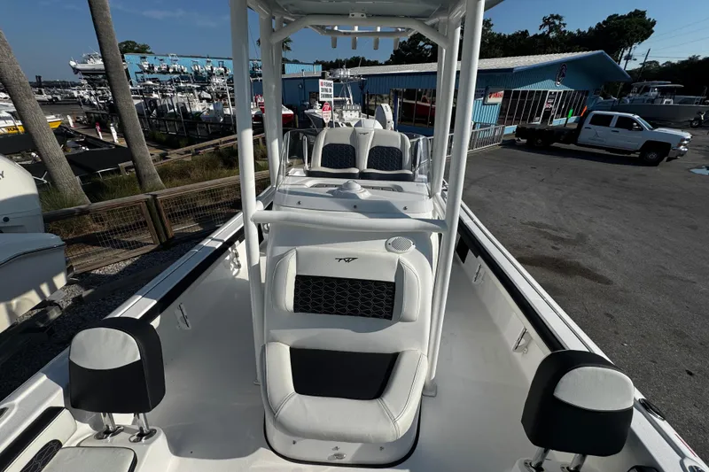 Slide: The Image of 2024 Tidewater 2300 Carolina Bay boat with seating, docked near a marina. - 13