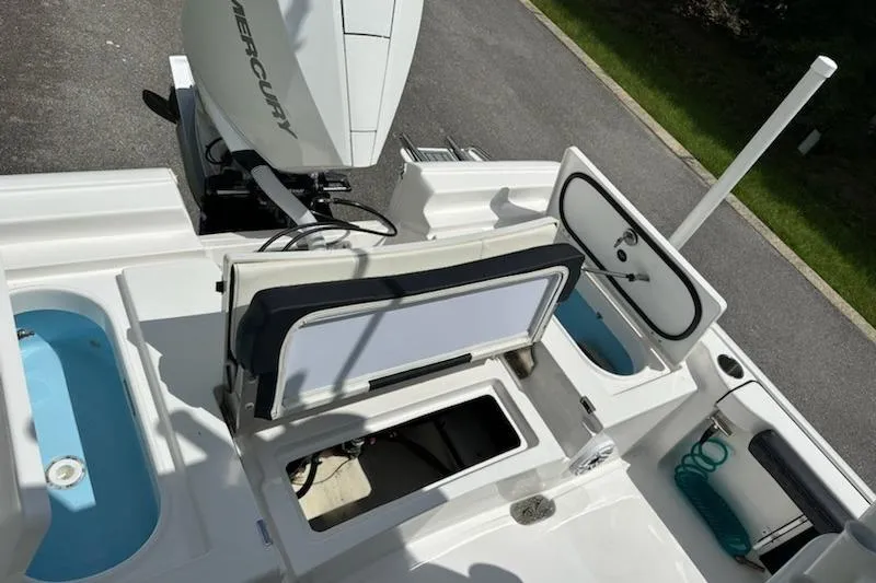 Slide: The Image of 2024 Tidewater 2300 Carolina Bay boat with open storage compartments and Mercury engine. - 19
