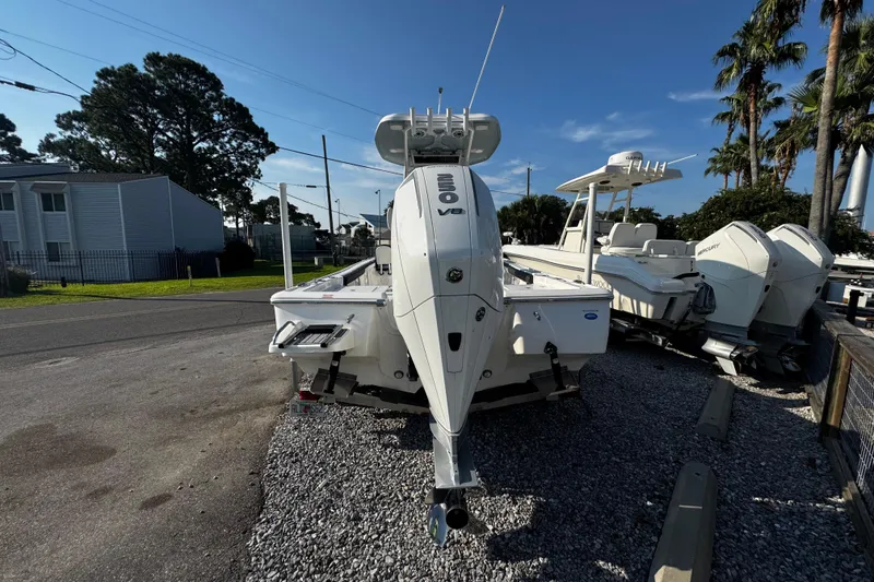 Slide: The Image of 2024 Tidewater 2300 Carolina Bay boat with powerful outboard motor, parked on gravel lot. - 2