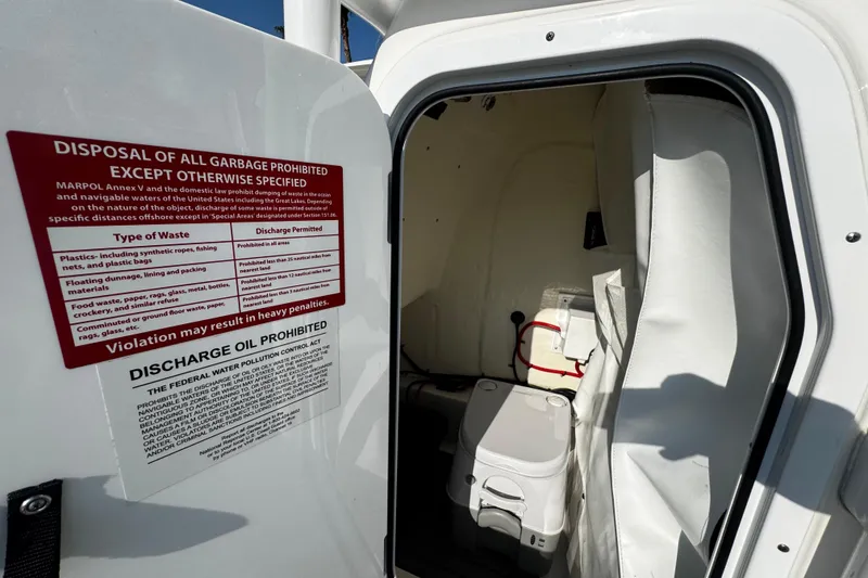 Slide: The Image of 2024 Tidewater 2300 Carolina Bay boat interior with waste disposal sign. - 20