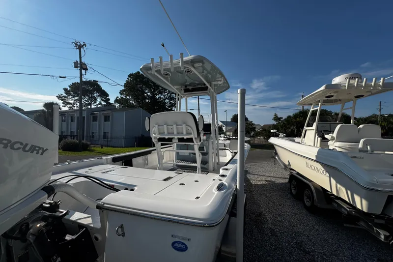 Slide: The Image of 2024 Tidewater 2300 Carolina Bay boat with Mercury engine, parked outdoors under clear sky. - 3
