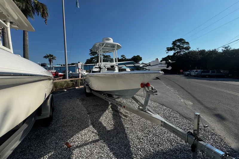 Slide: The Image of 2024 Tidewater 2300 Carolina Bay boat on trailer, parked outdoors under clear sky. - 6
