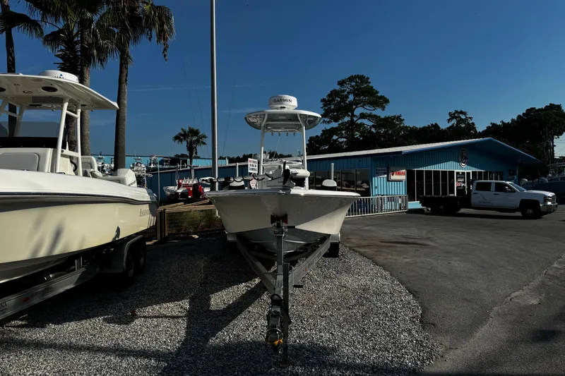 Slide: The Image of 2024 Tidewater 2300 Carolina Bay boat displayed at a dealership with palm trees and blue sky. - 7
