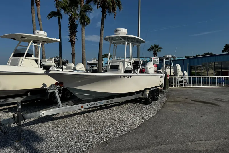 Slide: The Image of 2024 Tidewater 2300 Carolina Bay boat on trailer, parked near palm trees. - 8