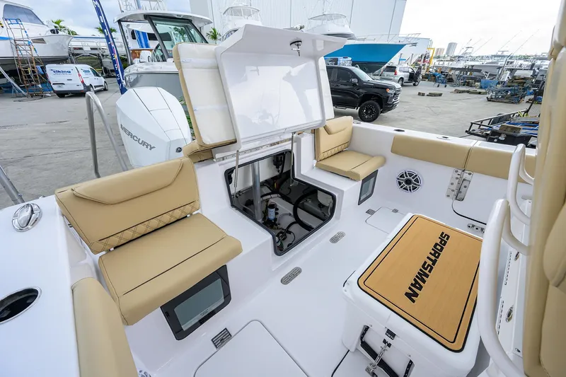 Slide: The Image of 2026 Sportsman Heritage 261 Center Console boat interior with tan seating and storage compartments. - 11