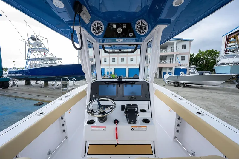 Slide: The Image of 2026 Sportsman Heritage 261 Center Console boat interior at marina, featuring modern controls. - 15