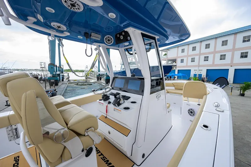 Slide: The Image of 2026 Sportsman Heritage 261 Center Console boat interior at marina, showcasing helm and seating. - 17