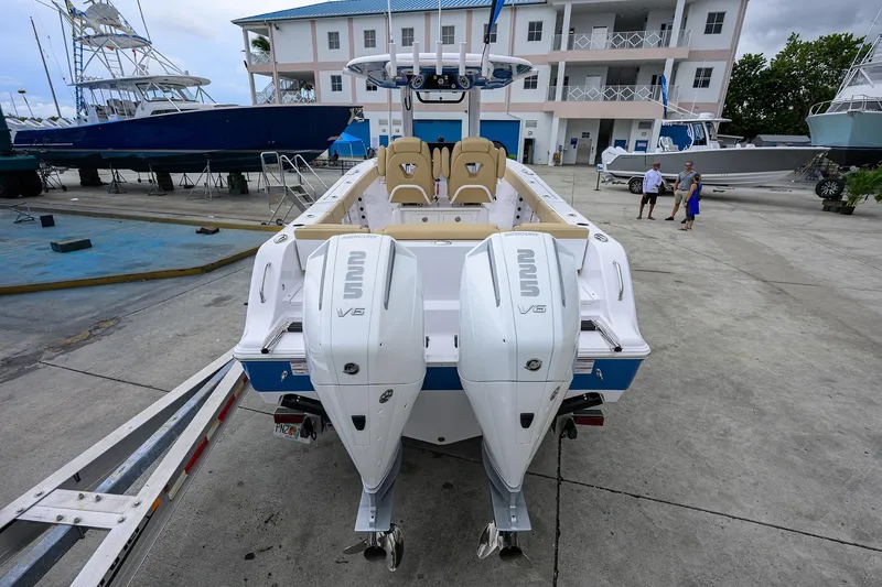 Slide: The Image of 2026 Sportsman Heritage 261 Center Console boat with dual engines at a marina. - 2