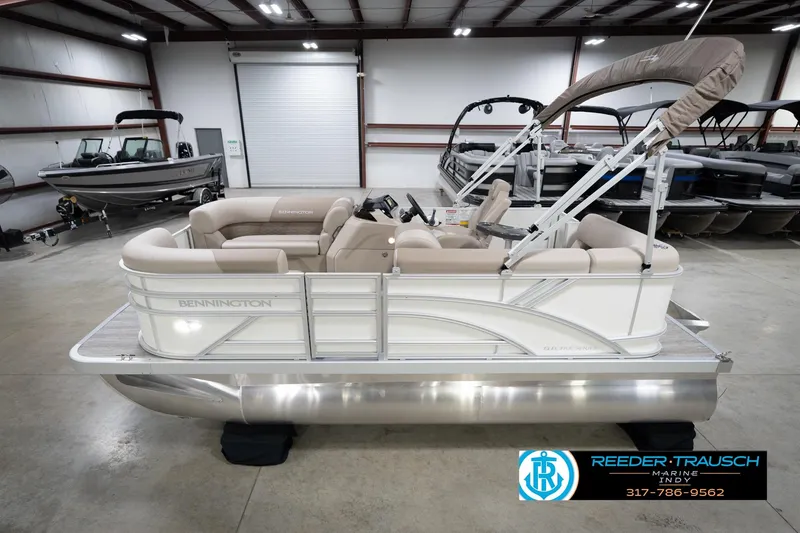 The Image of 2026 Bennignton 168 SL pontoon boat in showroom, featuring beige seating and canopy. - 1
