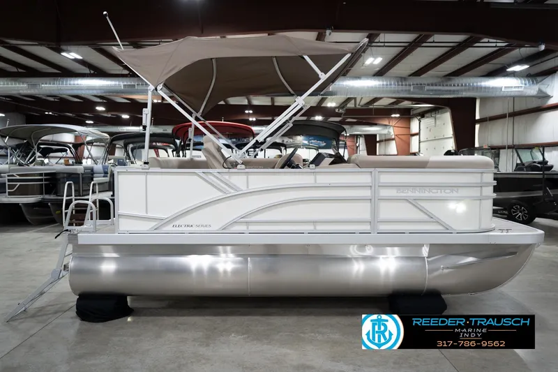 Slide: The Image of 2026 Bennignton 168 SL pontoon boat in showroom, featuring sleek design and canopy. - 6