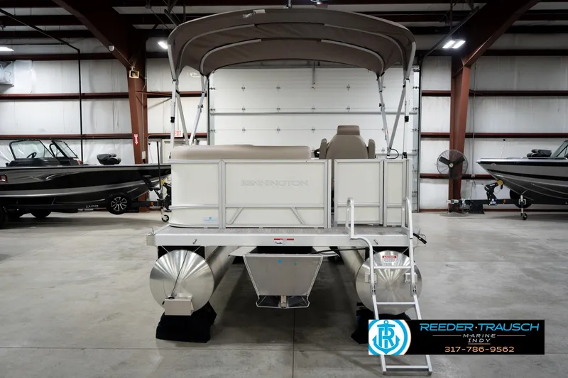 Slide: The Image of 2026 Bennignton 168 SL pontoon boat in showroom, rear view with canopy and ladder. - 8