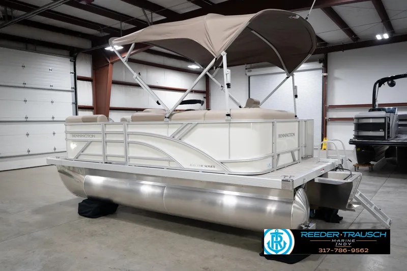 Slide: The Image of 2026 Bennignton 168 SL pontoon boat in a warehouse, featuring a beige canopy. - 9