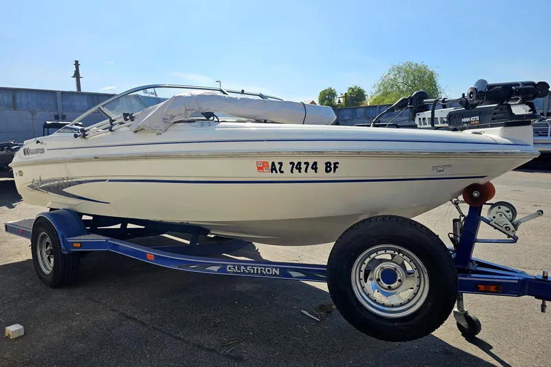 Slide: The Image of 2003 Glastron SFSX175 boat on trailer, parked outdoors under clear sky. - 4