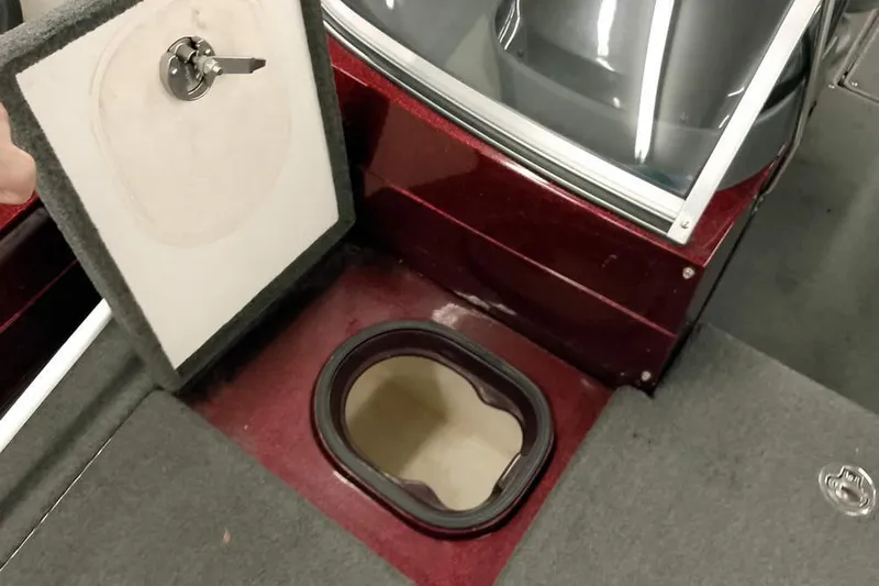 Slide: The Image of 2014 Ranger 621VS Fisherman boat with open storage compartment and carpeted interior. - 14