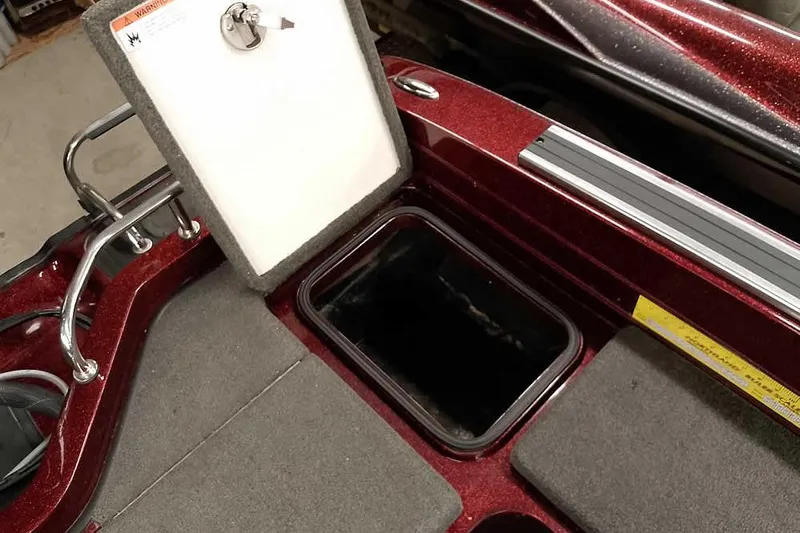 Slide: The Image of 2014 Ranger 621VS Fisherman boat storage compartment with open lid, red and gray interior. - 29