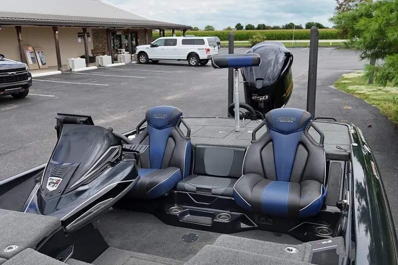 Slide: The Image of 2021 Skeeter FXR21 Apex boat with blue seats and powerful engine in parking lot. - 10