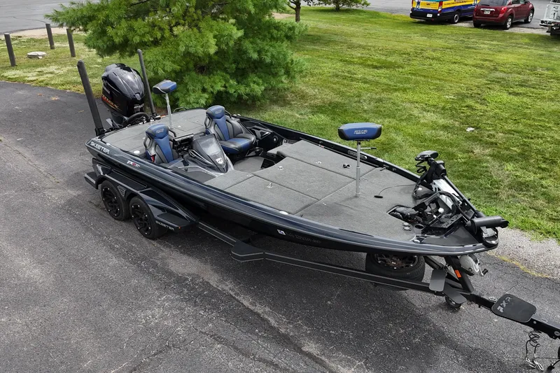 Slide: The Image of 2021 Skeeter FXR21 Apex bass boat on trailer, parked on asphalt near grass. - 16