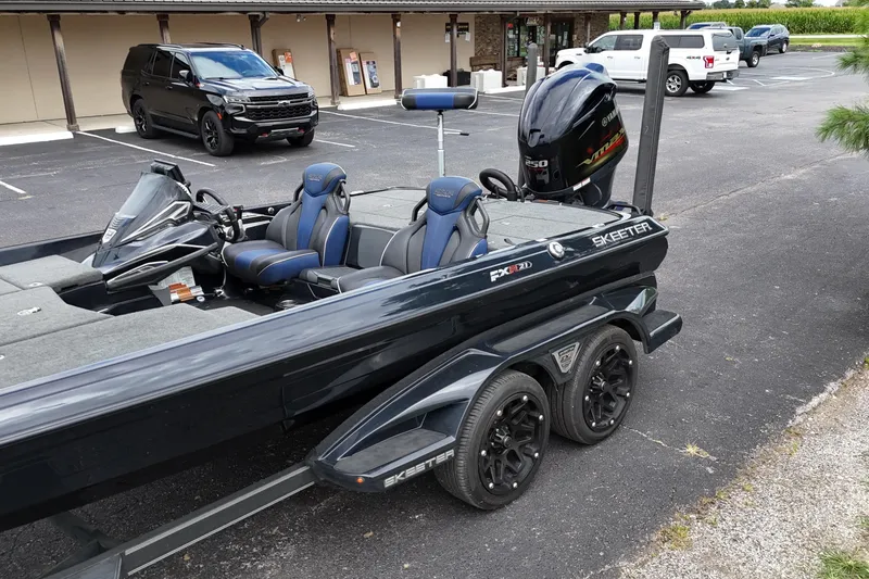 Slide: The Image of 2021 Skeeter FXR21 Apex boat on trailer in parking lot, featuring Yamaha engine. - 19
