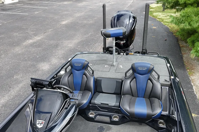 Slide: The Image of 2021 Skeeter FXR21 Apex boat interior with blue and black seating, parked on asphalt. - 21