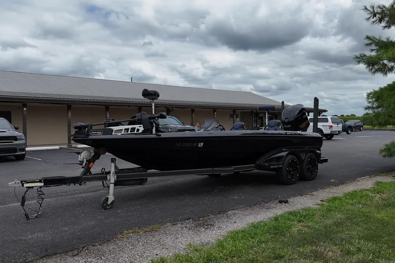 Slide: The Image of 2021 Skeeter FXR21 Apex boat on trailer, parked outdoors under cloudy sky. - 5