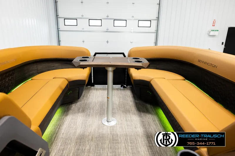 Slide: The Image of 2026 Bennington MFBSE boat interior with orange seating and central table in a showroom. - 20