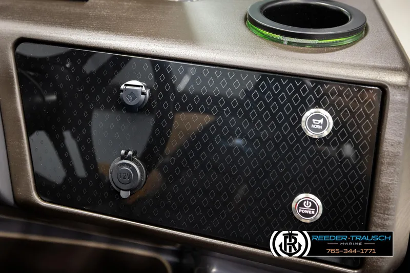 Slide: The Image of 2026 Bennington MFBSE control panel with power and horn buttons, 12V socket, and cup holder. - 35