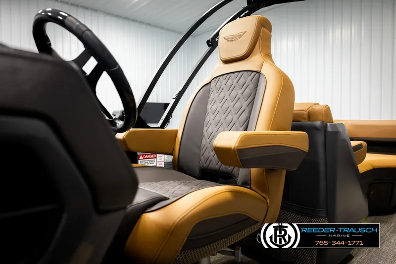 Slide: The Image of 2026 Bennington MFBSE boat interior with luxurious tan and gray seating, Reeder Trausch Marine logo. - 37