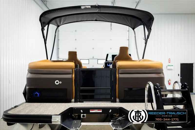Slide: The Image of 2026 Bennington MFBSE pontoon boat with canopy in showroom, rear view. - 7