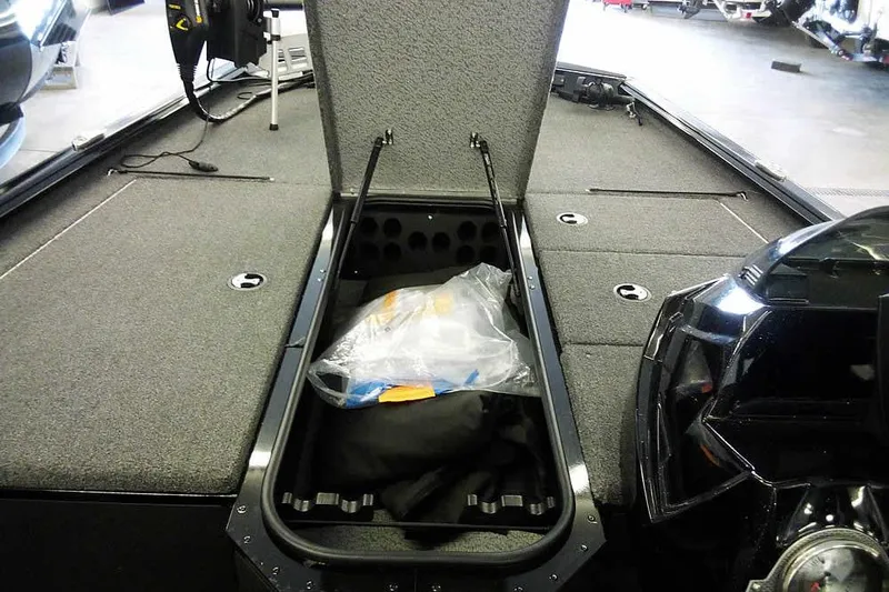 Slide: The Image of 2024 Lund 1775 Renegade boat interior with open storage compartment and motor. - 14