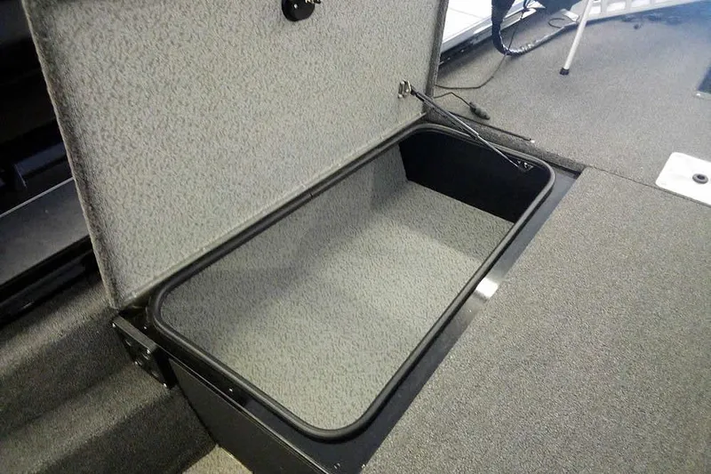 Slide: The Image of 2024 Lund 1775 Renegade boat storage compartment, open and carpeted interior. - 17