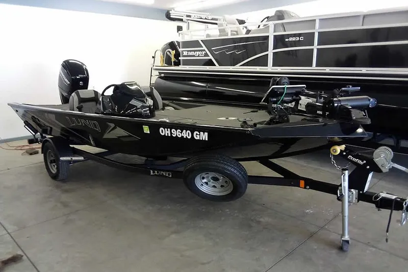 Slide: The Image of 2024 Lund 1775 Renegade fishing boat on trailer in garage setting. - 34