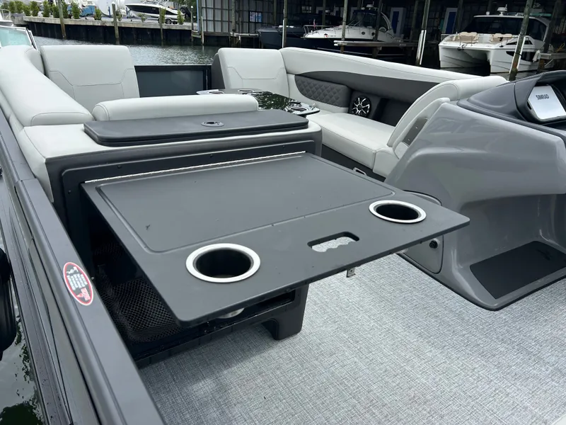 Slide: The Image of Interior of 2026 Harris Sunliner 230 pontoon boat with table and cup holders. - 23
