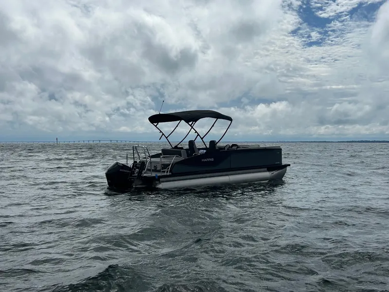Slide: The Image of Harris Sunliner 230 pontoon boat 2026 on open water under cloudy skies. - 4