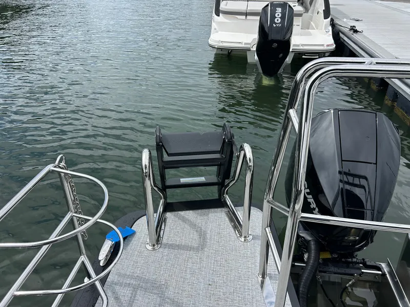Slide: The Image of Harris Sunliner 230 boat, 2026 model, with outboard motor at dock. - 9